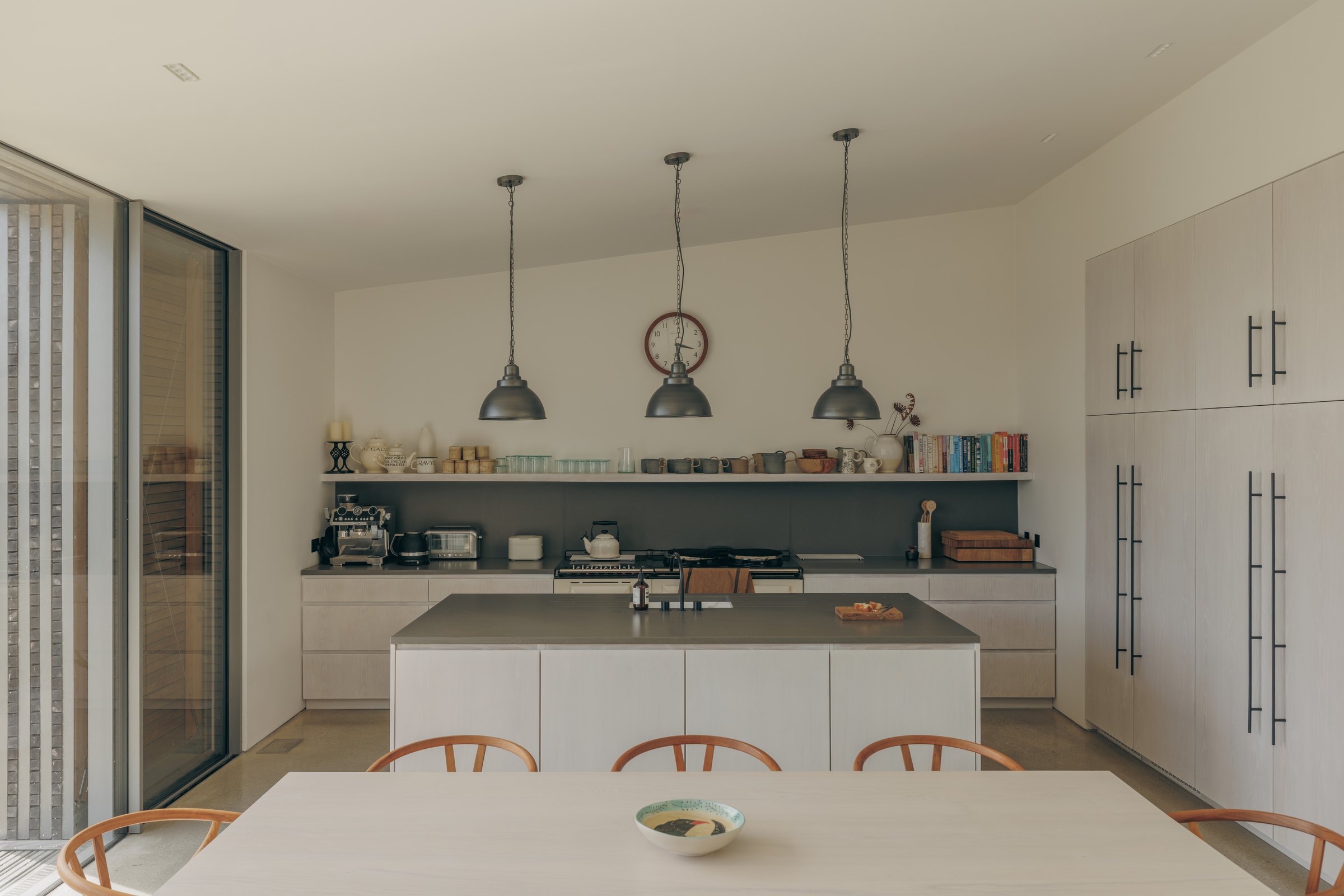 Kitchen and dining area with pale cabinetry and pendant lights at Bank Cottage, Bryher