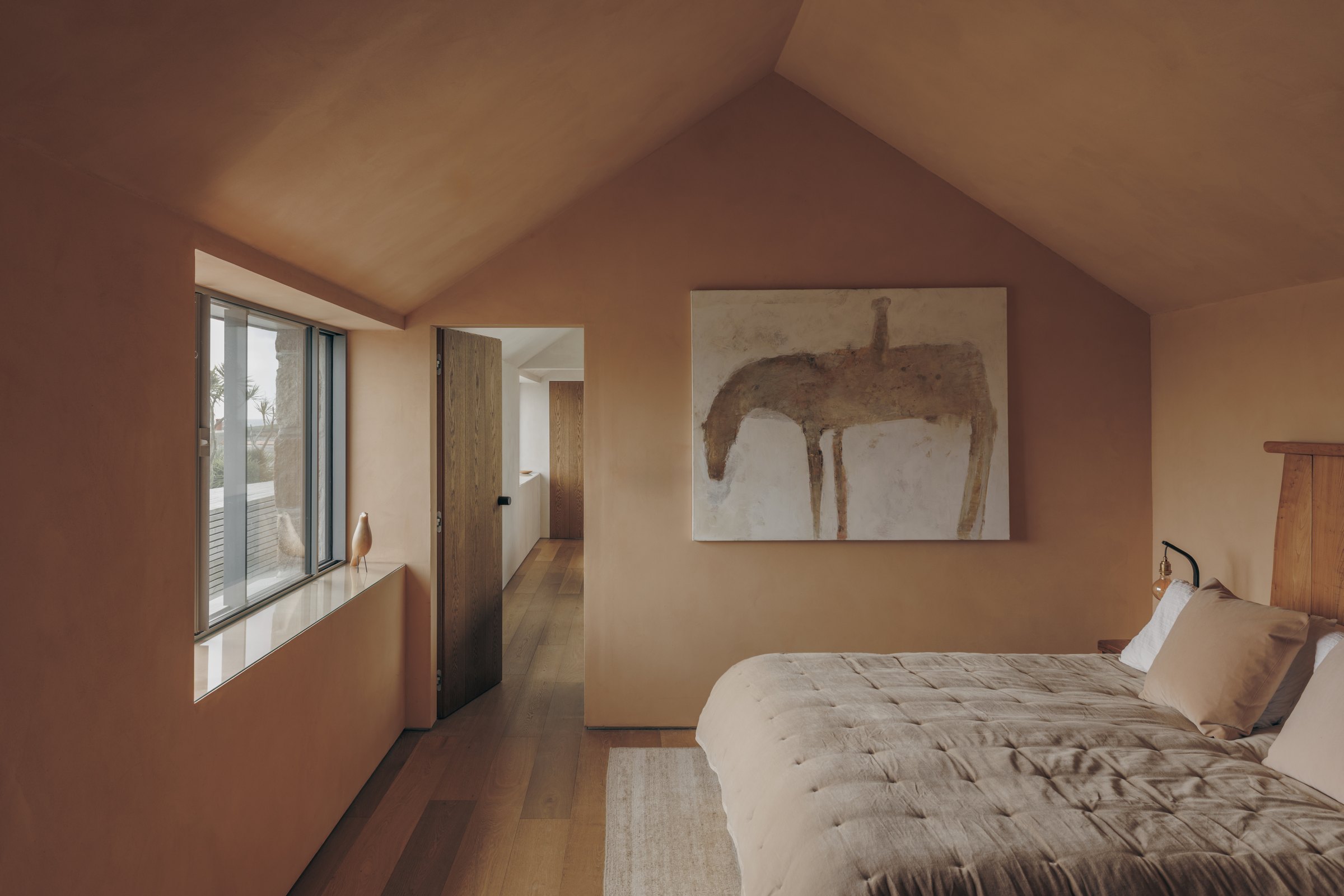 Bedroom beneath the pitched roof of the renovated granite cottage on Bryher