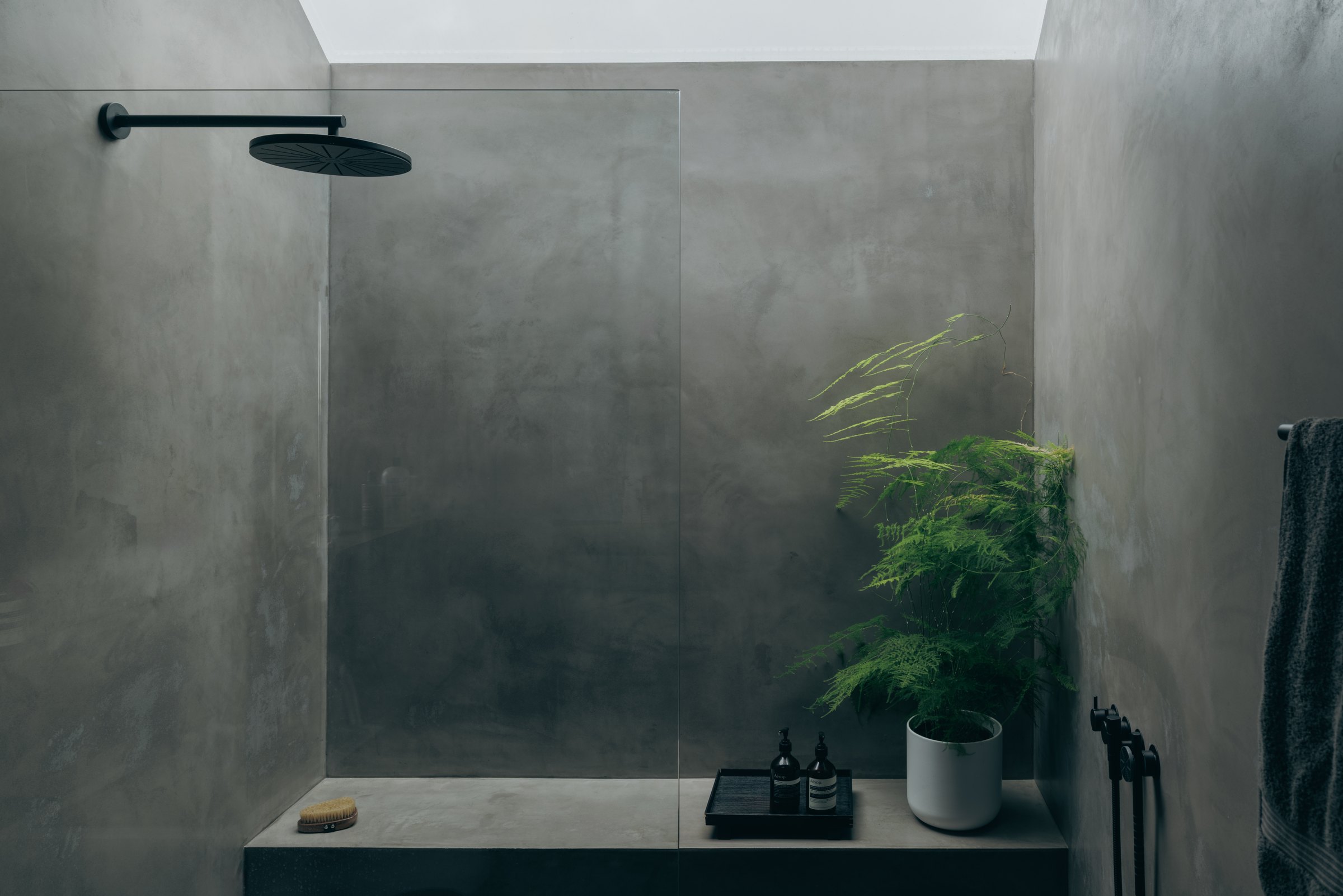 Rooflit shower room with grey walls and black fittings at Bank Cottage, Bryher
