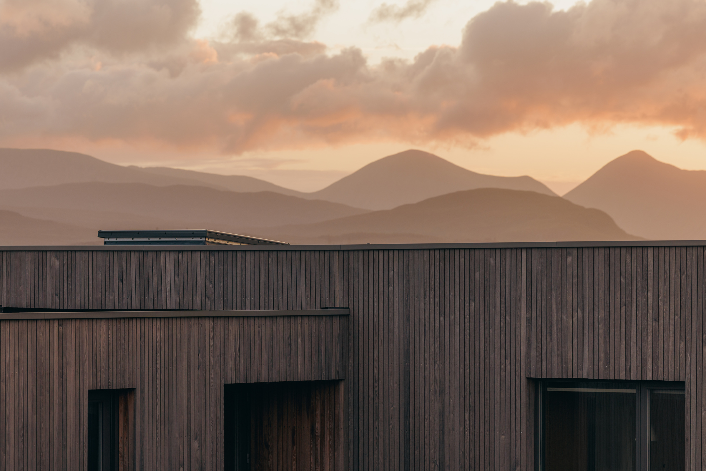 Half of Eleven — timber roofline and mountain silhouettes