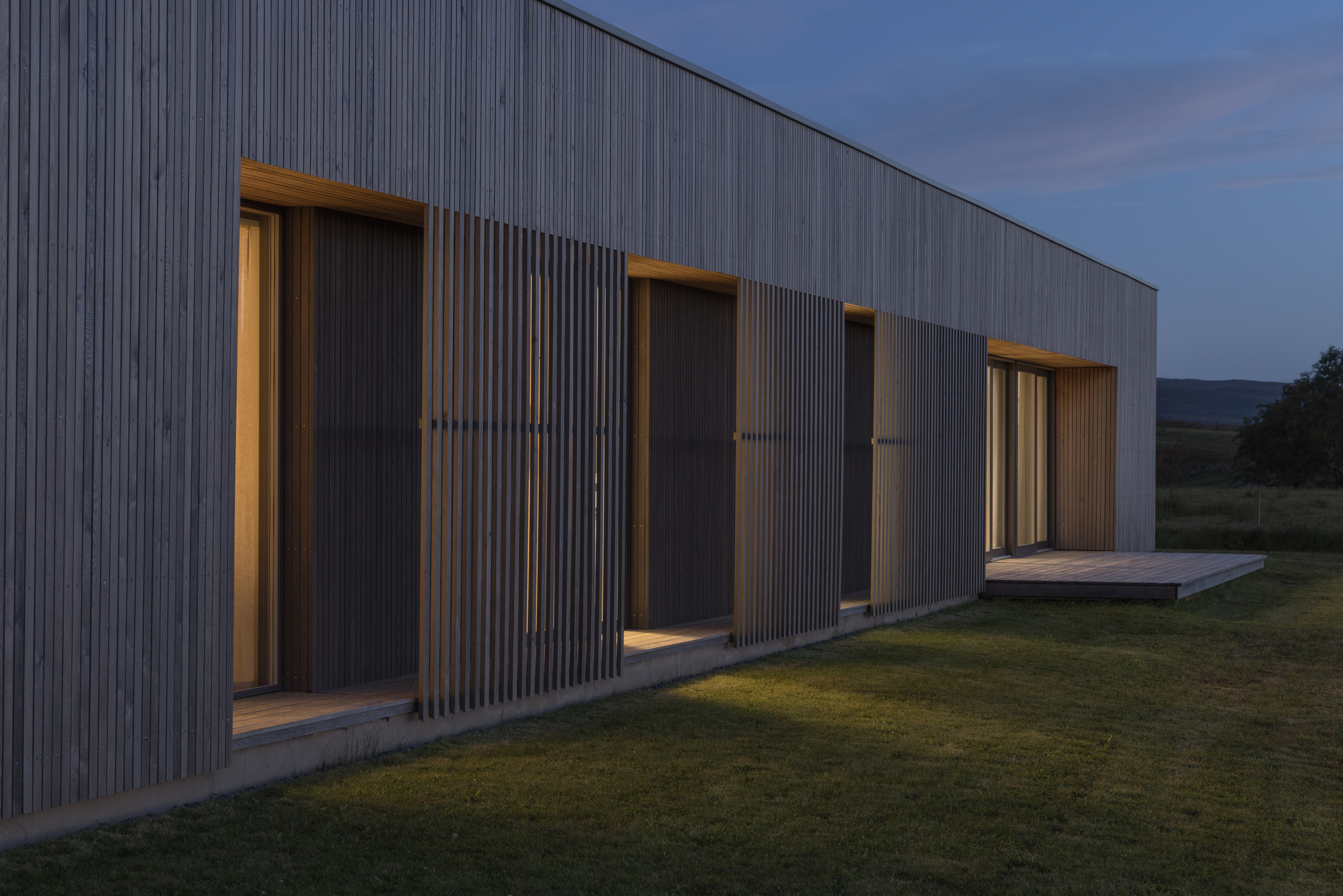 Half of Eleven — recessed windows and timber screens at dusk