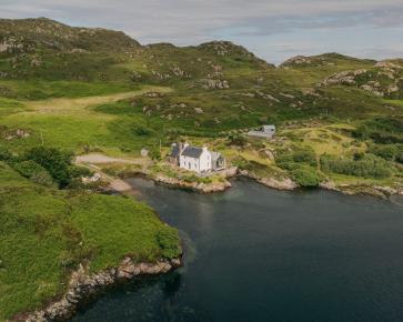 At Fanagmore in Sutherland, a former school and schoolhouse stood in a remarkable setting at the end of a winding road, overlooking a sea loch. Time, neglect and a succession of unsympathetic additions had left both buildings in a dilapidated condition, yet their inherent character and extraordinary location remained undiminished.

Sketched in a roadside lay-by on the journey home from the first site visit, the architectural response arrived almost immediately

The proposal links the two existing buildings with a new parallel pitched-roof structure containing a glazed entrance, utility, study and open-plan living space. A carefully framed axial view extends from the former classroom, now a kitchen and dining room, through the new extension to the loch beyond. The restored schoolhouse accommodates three bedrooms and two shower rooms, while the new addition sits quietly between and behind the original buildings, almost as though it has always occupied their shadow.

The result is an economical and understated solution that celebrates the existing architecture, carefully restoring its character while allowing it to begin a new chapter as a family home.

Completed in 2019, the project was revisited this summer by photographer Richard Gaston @richardgaston , whose new photographs capture the house as it has settled naturally into its landscape, framed by a garden that has been thoughtfully cultivated and lovingly maintained by its owners.
 
#architecture #scottisharchitecture #restoration  #exstention #oldschoolhouse
